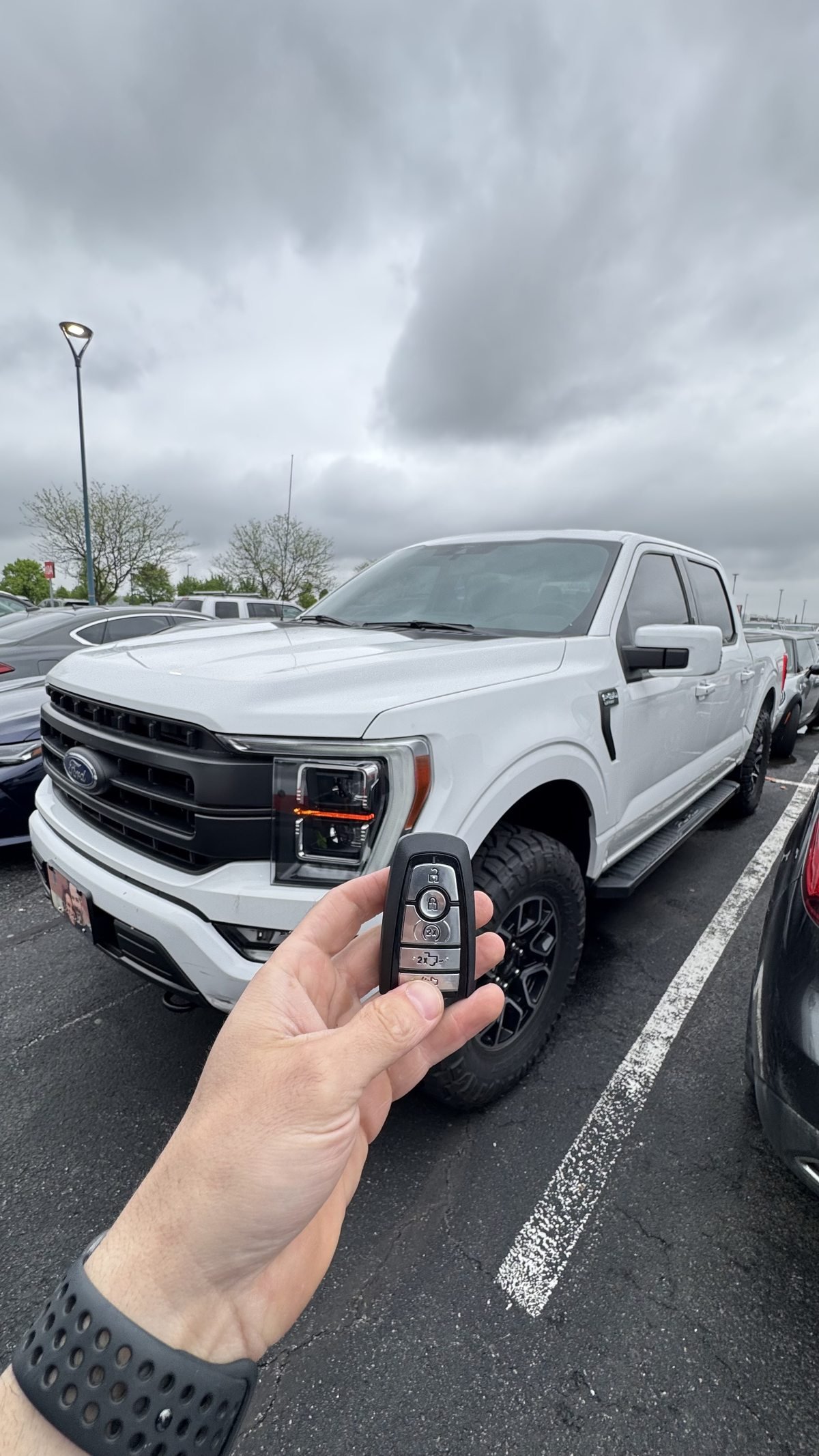 Locksmith Powell Ohio technician holding Ford F-150 smart key fob after programming in Powell Ohio parking lot